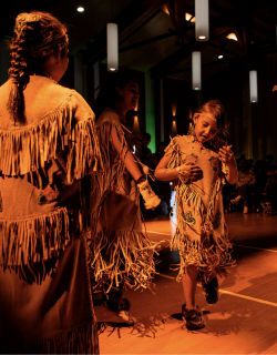 Two Indigenous dancers wearing traditional clothing